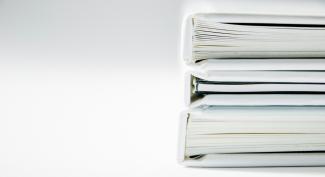A stack of thick folders on a white surface by Beatriz Pérez Moya courtesy of Unsplash.